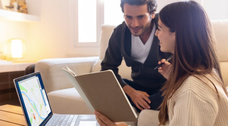 A couple using a laptop with maps to explore real estate automation software for their home search., missed call text back software for real estate, Missed call recovery for real estate agents